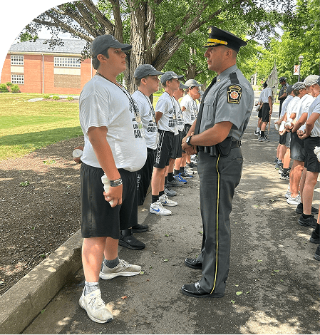 Officer standing in front of cadets in camp